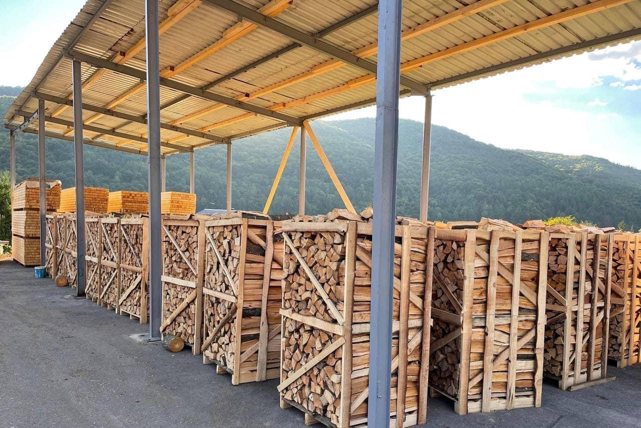 Seasoned split firewood logs stacked and ready for kiln drying